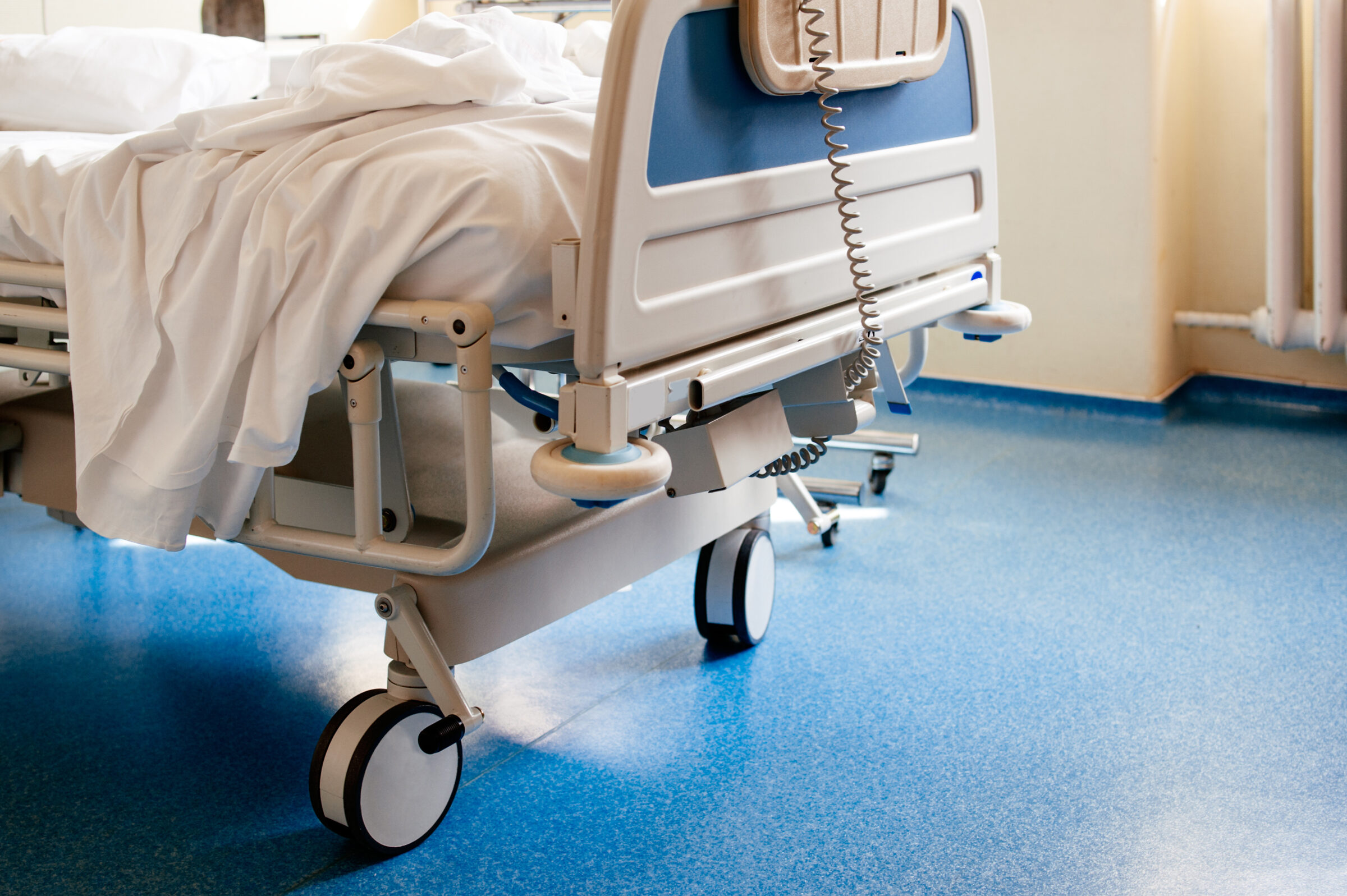 Empty hospital bed on hospital ward in a clean room