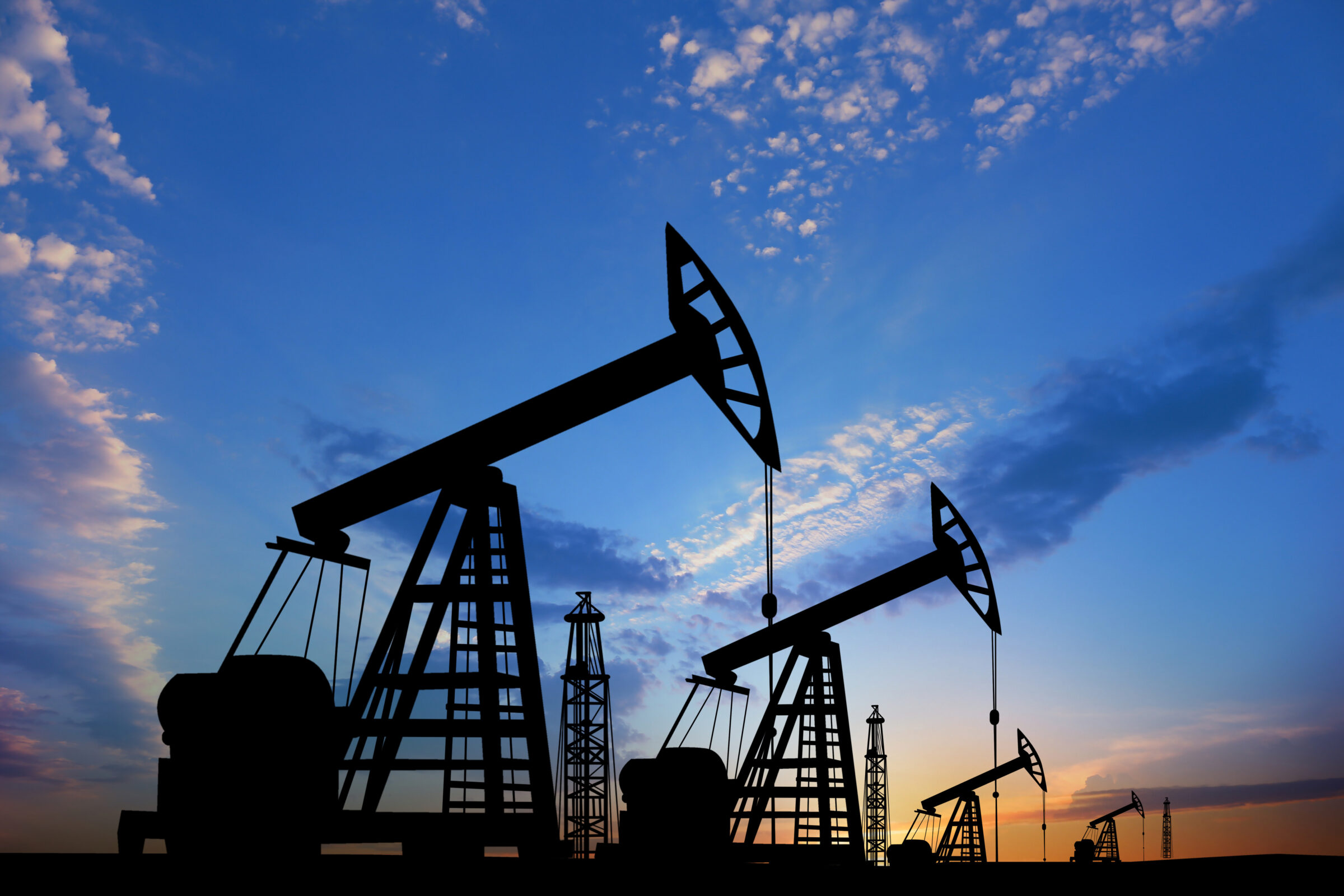 Silhouettes of crude oil pumps at sunset