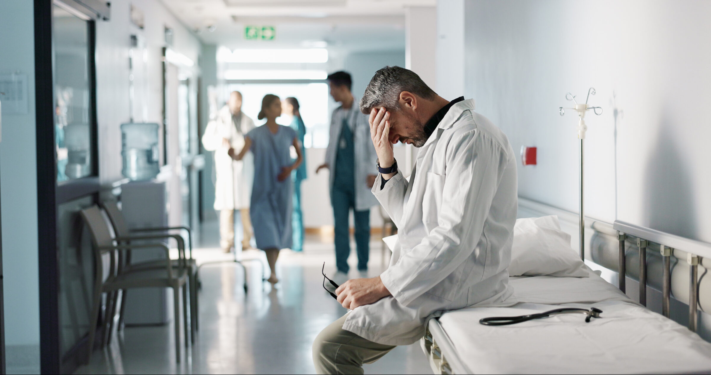 Depression, grief or fail with a mature doctor in a hospital looking unhappy for healthcare or medical. Stress, mistake or loss with a sad man medicine professional in a professional medicare clinic