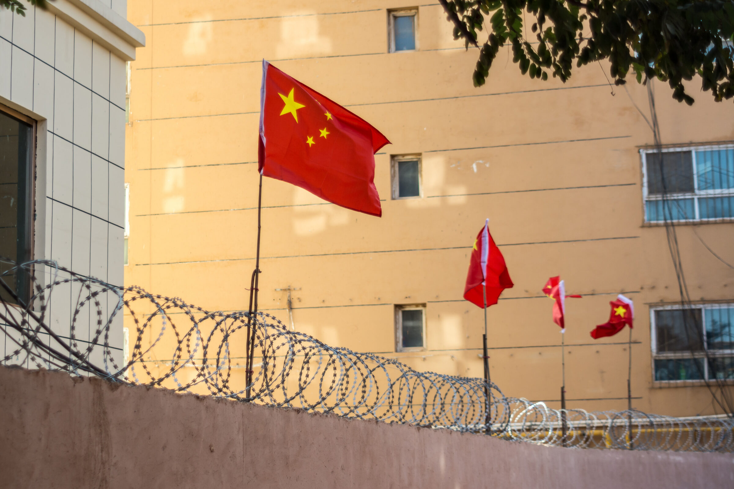 Chinese flags on barbed wire wall in Kashgar (Kashi), Xinjiang, China.
